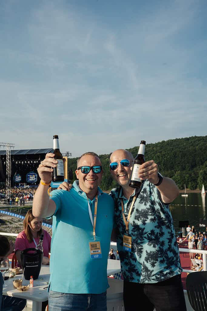 Genießer beim Biggesee Open Air 2026 mit Blick auf die Festivalbühne am Ufer.